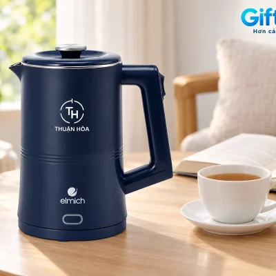 Mô phỏng ấm Elmich KEE9148 demo THUẬN HÒA cạnh cốc trà và sách tại góc nghỉ