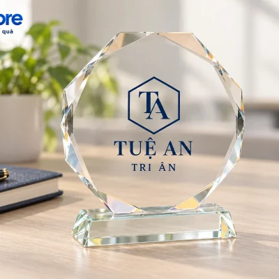 Mô phỏng biểu trưng bát giác TUỆ AN TRI ÂN đặt trên bàn cạnh sổ và bút