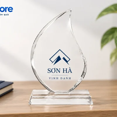 Mô phỏng biểu trưng ngọn lửa SƠN HÀ đặt trên mặt gỗ cạnh sổ navy và cây