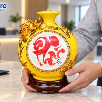 Mô phỏng người áo xám đỡ đế và thân dưới khi đặt bình chữ Phúc demo AN MINH trên bàn đá