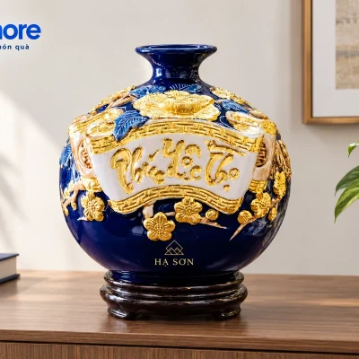 Mô phỏng bình cuốn thư xanh đậm demo HẠ SƠN trên kệ gỗ cạnh sách navy và cây