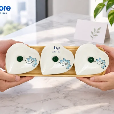 Hai người đỡ hai đầu khay khi trao bộ ba hũ tim sen xanh đóng nắp