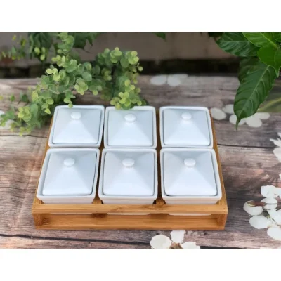 Ảnh nguồn đủ sáu hũ mứt trắng có nắp trên khay gỗ với thanh bên và đáy