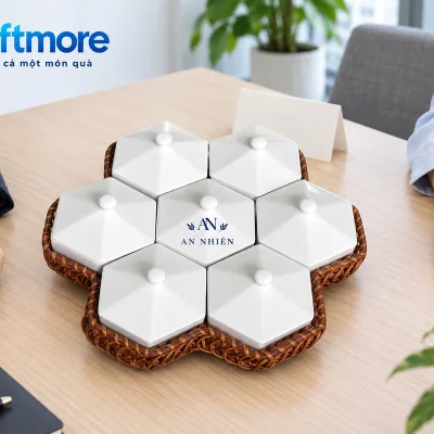 Hai người xem bộ bảy hũ tổ ong trắng đặt trên bàn trong cảnh trao quà