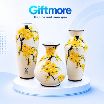 Demo AN GIA trên khoảng trắng phía dưới của lọ cao trong bộ ba lọ hoa vàng