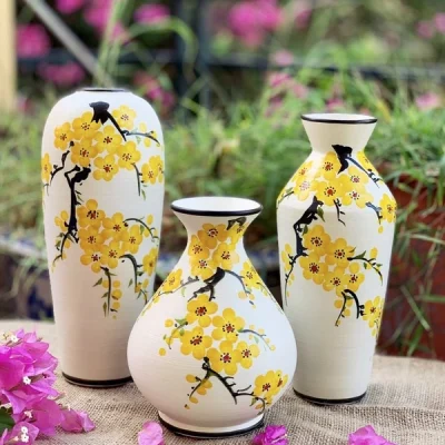 Ảnh gốc bộ ba lọ hoa vàng viền đen bày trên vải thô