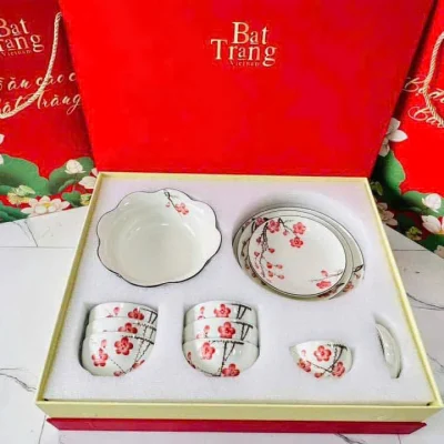 Tư liệu bộ bát đĩa hoa đỏ trong hộp chèn trắng, phía sau có túi và hộp mẫu