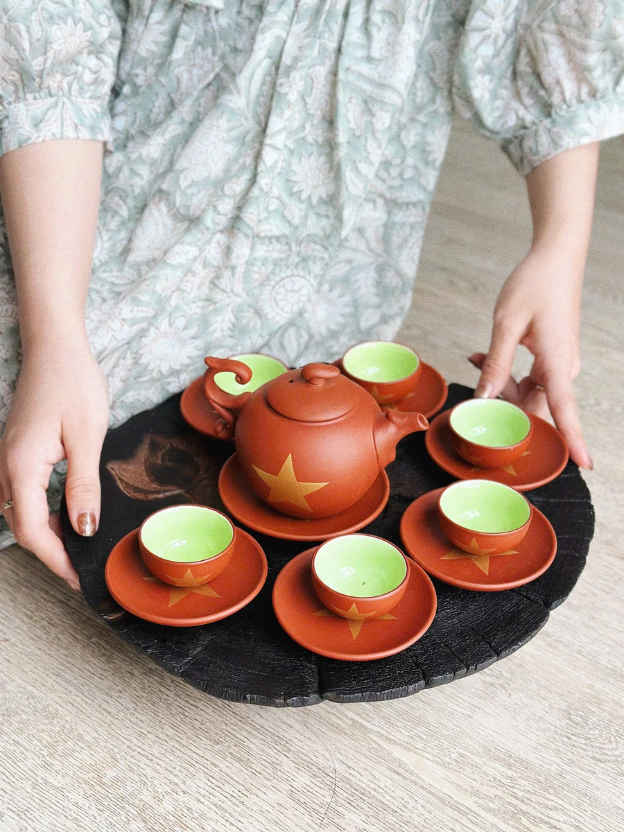 Bộ trà đỏ nâu trang trí ngôi sao vàng trên khay trong ảnh thật