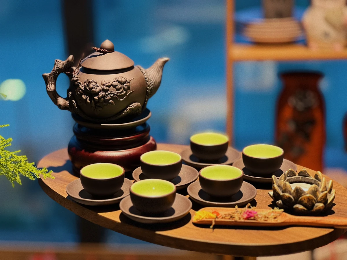 Mẫu ấm nâu hoa nổi, quai vòi dạng cành và các chén lòng xanh trong ảnh nguồn