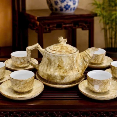 Tư liệu bộ trà Trúc vân đá kem nâu trơn với sáu chén, đĩa chén và đĩa kê ấm