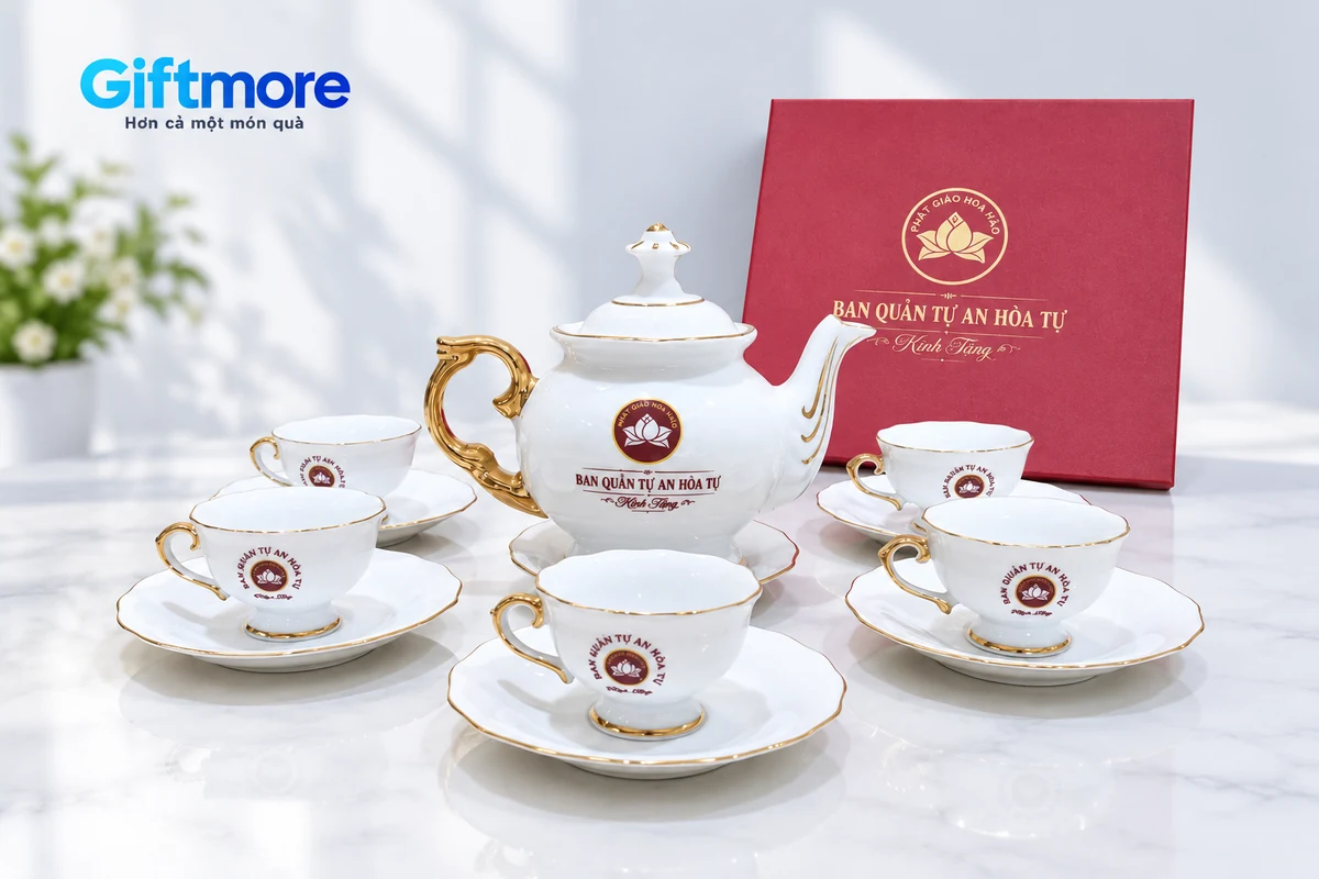 Bộ trà trắng viền vàng với nhận diện đỏ và hộp đồng bộ trong ảnh đã chỉnh nền