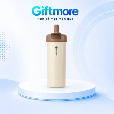 Cốc Elmich EL1658 thân kem, nắp nâu và miệng uống dựng trên bục GiftMore