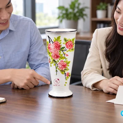 Hai người xem lọ hoa hồng để trống trên bàn và vị trí demo HA HOA AN ở thân dưới
