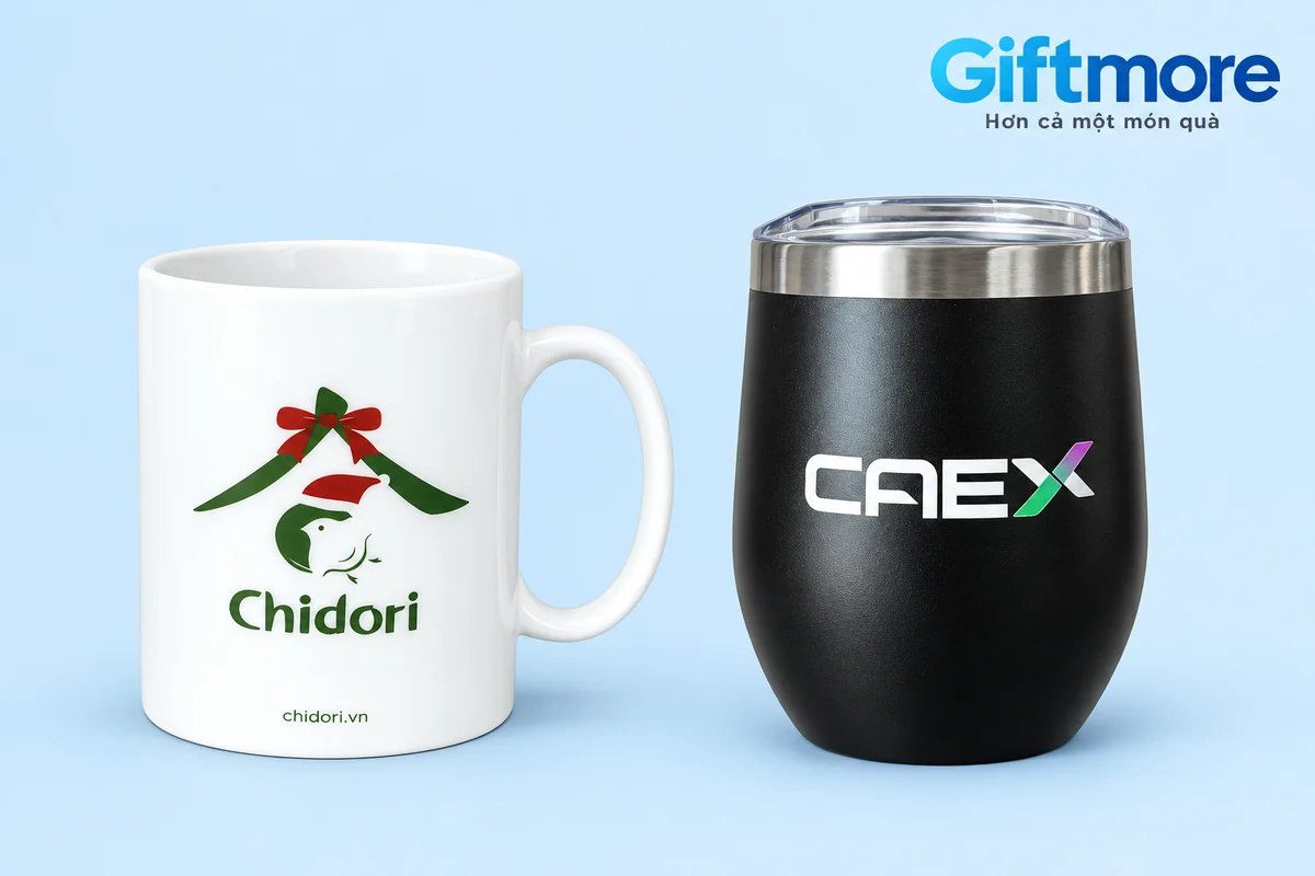 Ca sứ Chidori quai cong bên cạnh ly đen CAEX viền bạc trên nền xanh nhạt