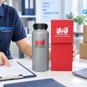 Tay đối chiếu phiếu bên bình xám và hộp đỏ MINH DUC GROUP cùng kiện carton