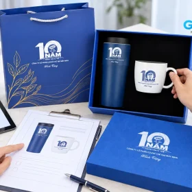 Bàn đối chiếu phiếu và bản xem bên bộ quà MHA có bình, ly và hộp xanh
