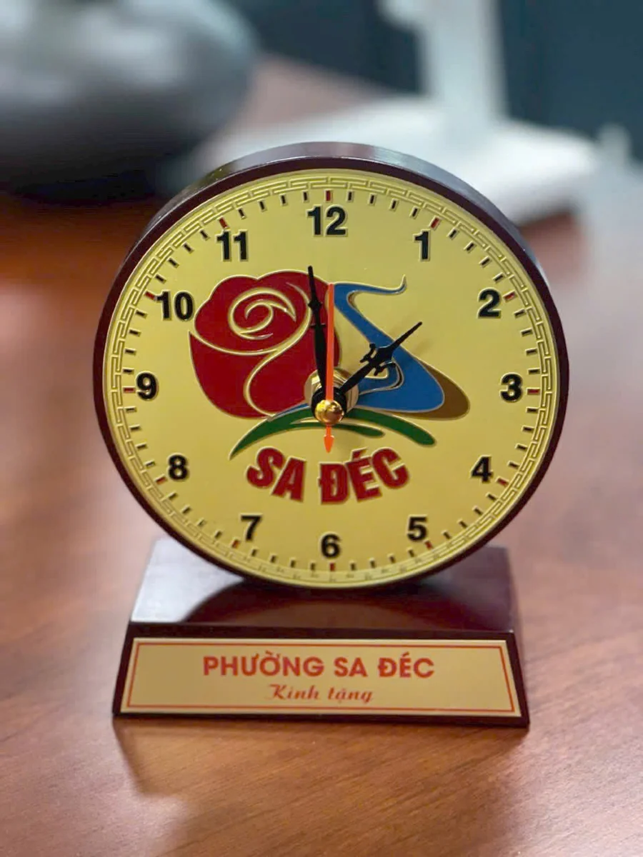 Ảnh thực nguồn đồng hồ mặt đồng ăn mòn với mẫu nhận diện Sa Đéc trên bàn