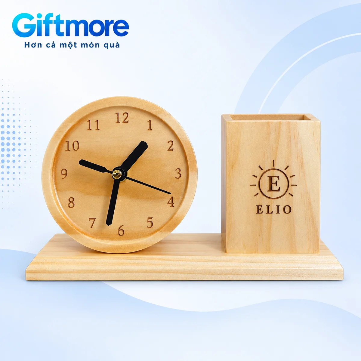Demo monogram E trong vòng mặt trời và tên ELIO trên ống bút gỗ cạnh đồng hồ