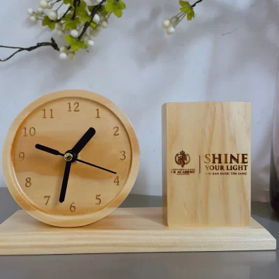 Ảnh nguồn đồng hồ tròn và ống bút gỗ có nội dung khắc trên mặt ống