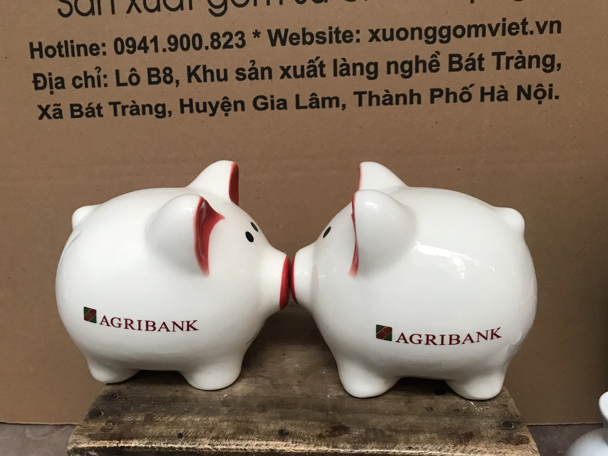 Ảnh thật hai heo trắng in Agribank ở hai bên thân