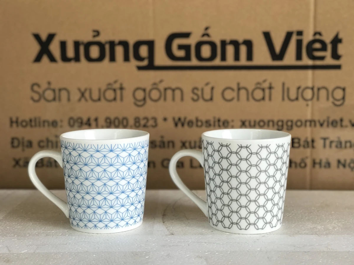 Hai ly trắng phủ họa tiết hình học xanh và xám trong ảnh thật