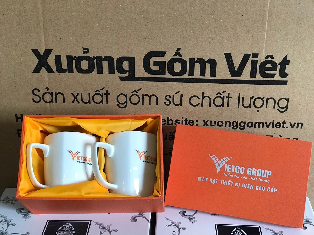 Hai ly trắng in VIETCO GROUP nằm trong hộp cam lót vải vàng