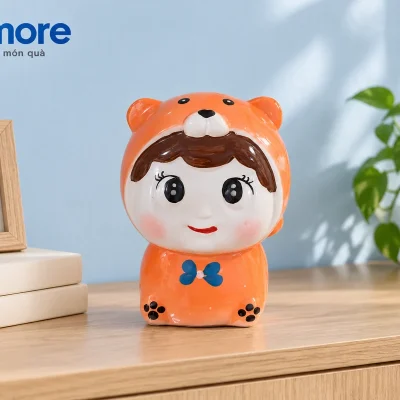 Mô phỏng búp bê áo cam nơ xanh cạnh sách kem và khung ảnh trống trên tủ gỗ