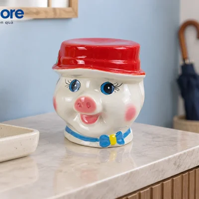 Mô phỏng heo mũ đỏ nơ xanh trên bàn đá sáng gần lối vào nhà