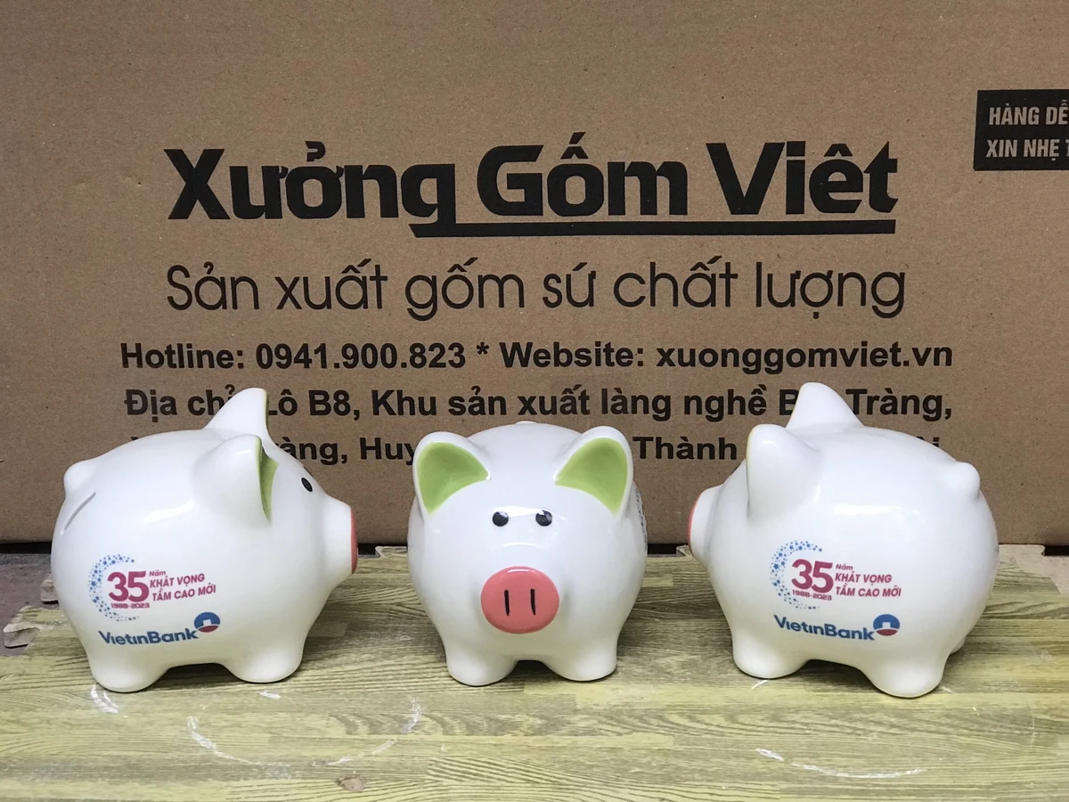 Ảnh thật ba heo trắng tai xanh lá với logo VietinBank nhìn từ trước và hai bên