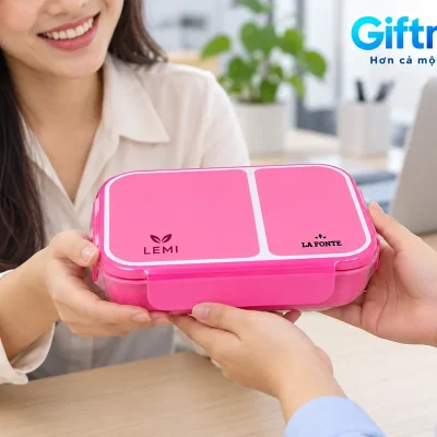 Mô phỏng trao một hộp cơm La Fonte hồng đóng nắp với LEMI và dấu La Fonte tại văn phòng