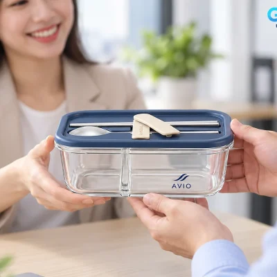 Mô phỏng trao một hộp cơm thủy tinh AVIO nắp navy có muỗng đũa tại văn phòng