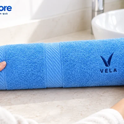 Mô phỏng lấy một khăn cotton xanh demo VELA trên bàn khô cạnh chậu rửa