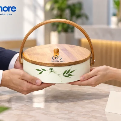 Người lớn trao khay mứt lá trúc đóng nắp với nhận diện demo THANH TRÀ