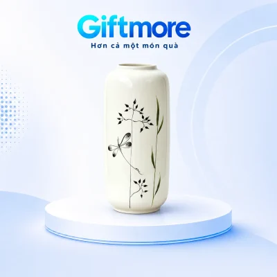 Lọ hoa dáng ống trắng với chuồn chuồn đen và cành lá trên nền GiftMore