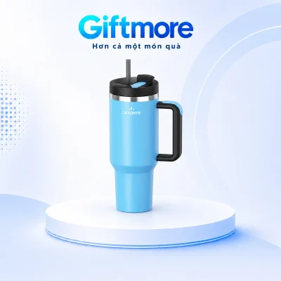 Ly La Fonte màu xanh có quai đen bên phải và ống hút trên bục GiftMore