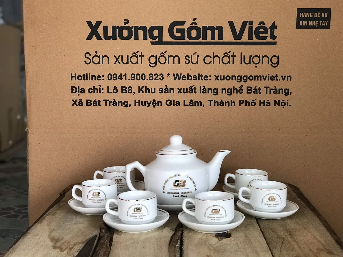 Bộ ấm trắng viền kim loại trong ảnh thật với sáu chén và đĩa