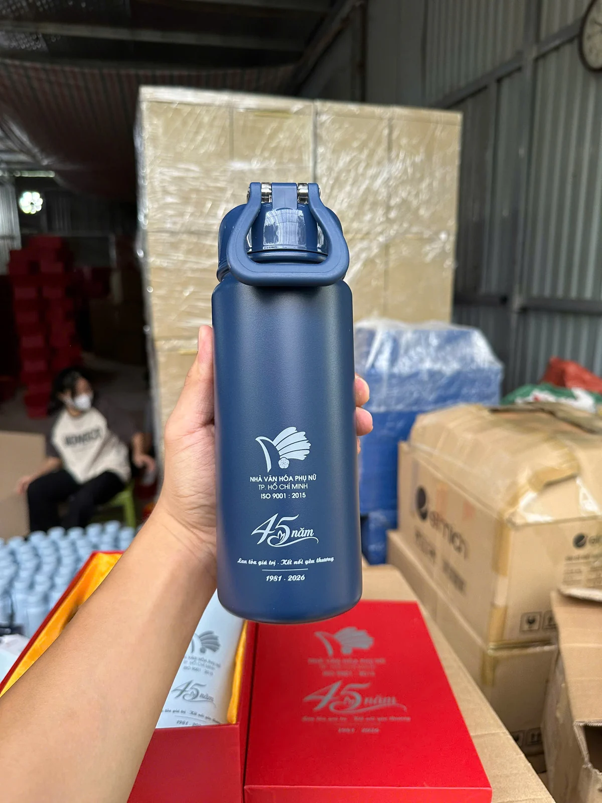 Bình xanh có quai gập và nội dung in trắng được cầm trên tay