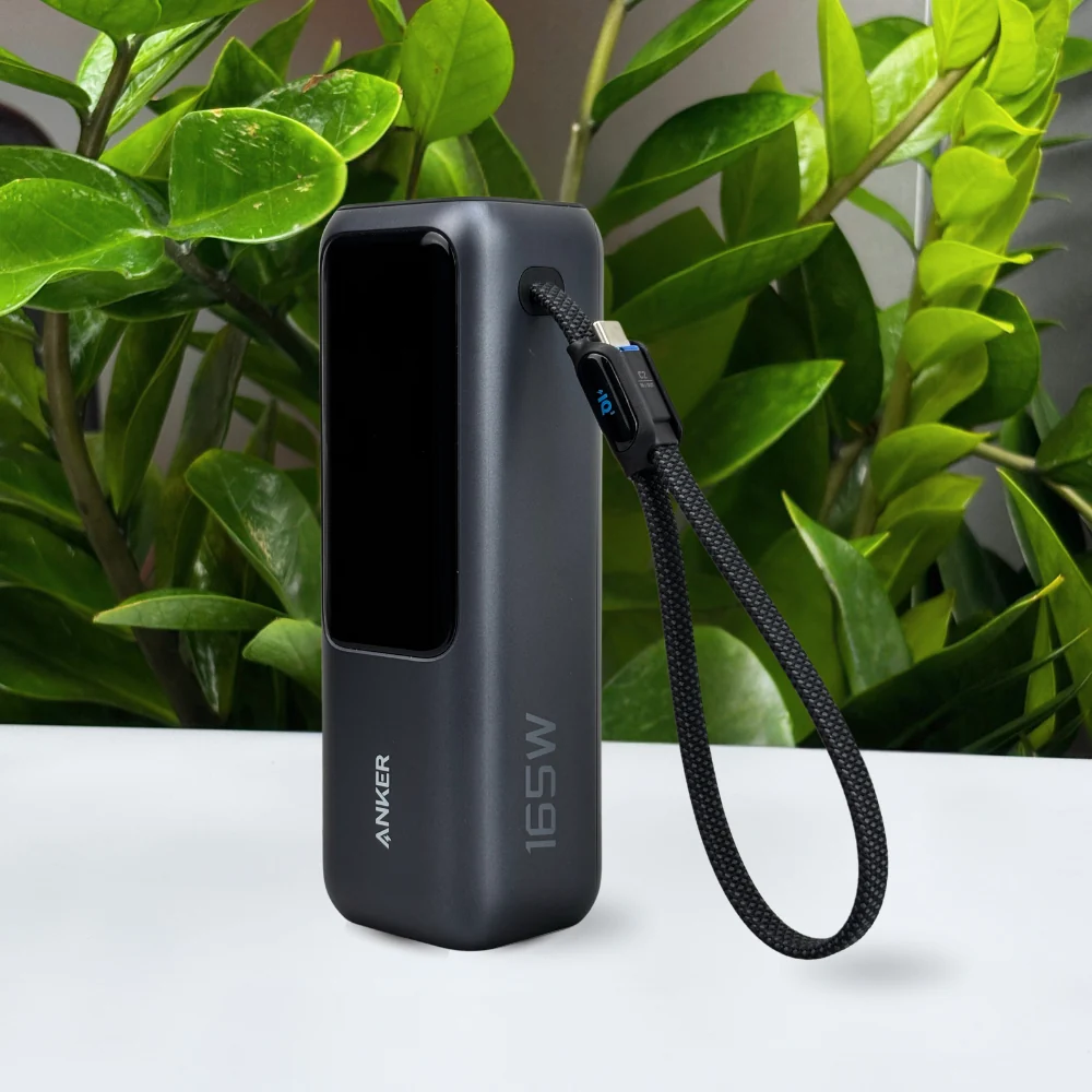 Tư liệu Anker A1695 màu tối đặt trên bàn, màn hình đen và dây USB-C bện tạo vòng bên hông