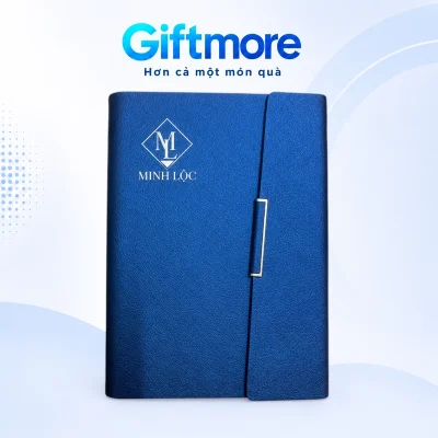 Mô phỏng monogram ML và tên MINH LỘC màu bạc trên bìa xanh của sổ gập chéo