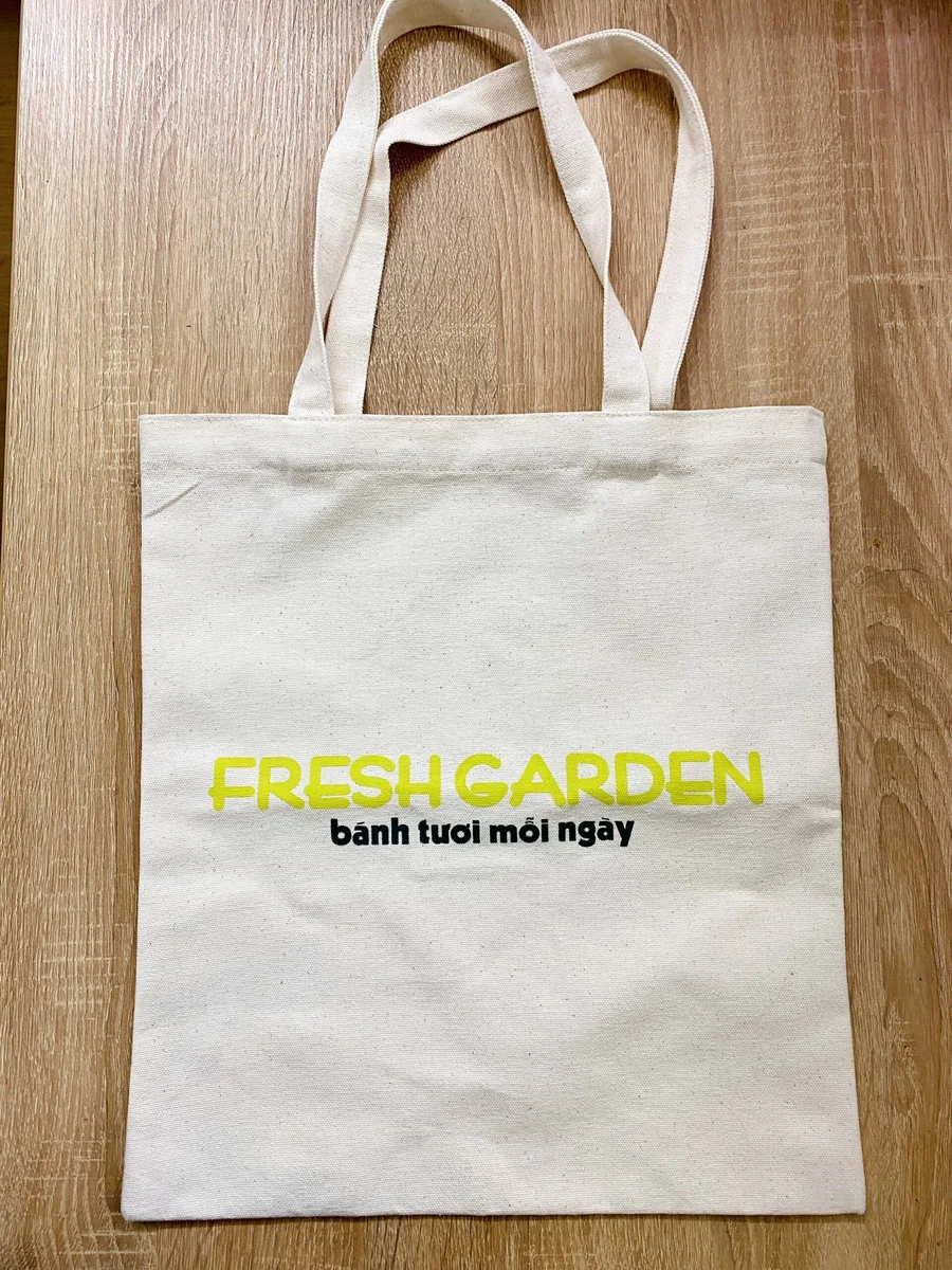Ảnh thật túi canvas mộc FRESHGARDEN trên sàn gỗ, hai quai cùng màu và mặt vải nhìn rõ