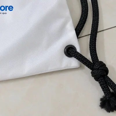 Cận cảnh mô phỏng khoen góc đáy túi trắng, dây bện đen và nút thắt theo ảnh mẫu